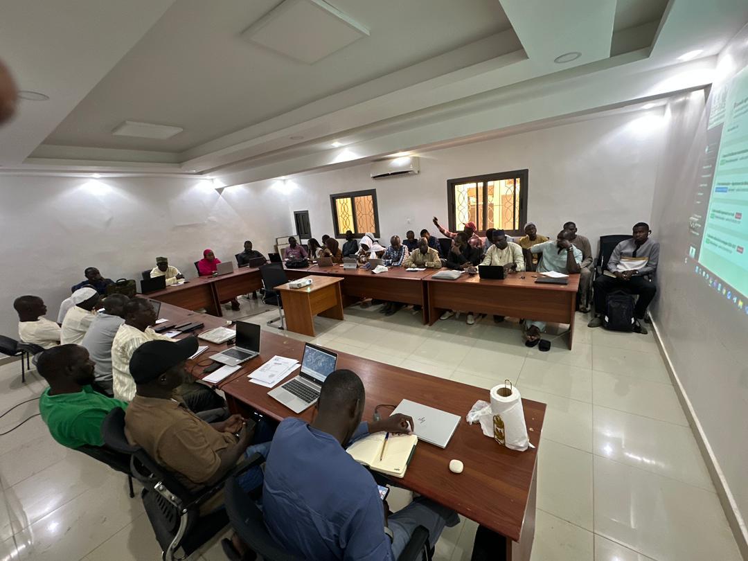 Salle de formation ERP-PAS : participants installés autour des tables suivent la présentation projetée